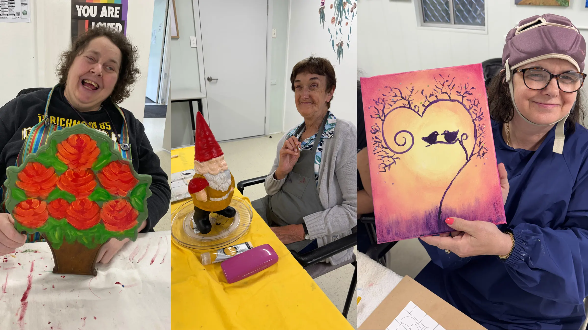 Three photographs from the art class, side by side: a woman holding a wooden cut-out painted with orange roses, a woman at a table with a garden gnome she is painting, and a woman holding a canvas of two birds in a heart-shaped tree at sunset